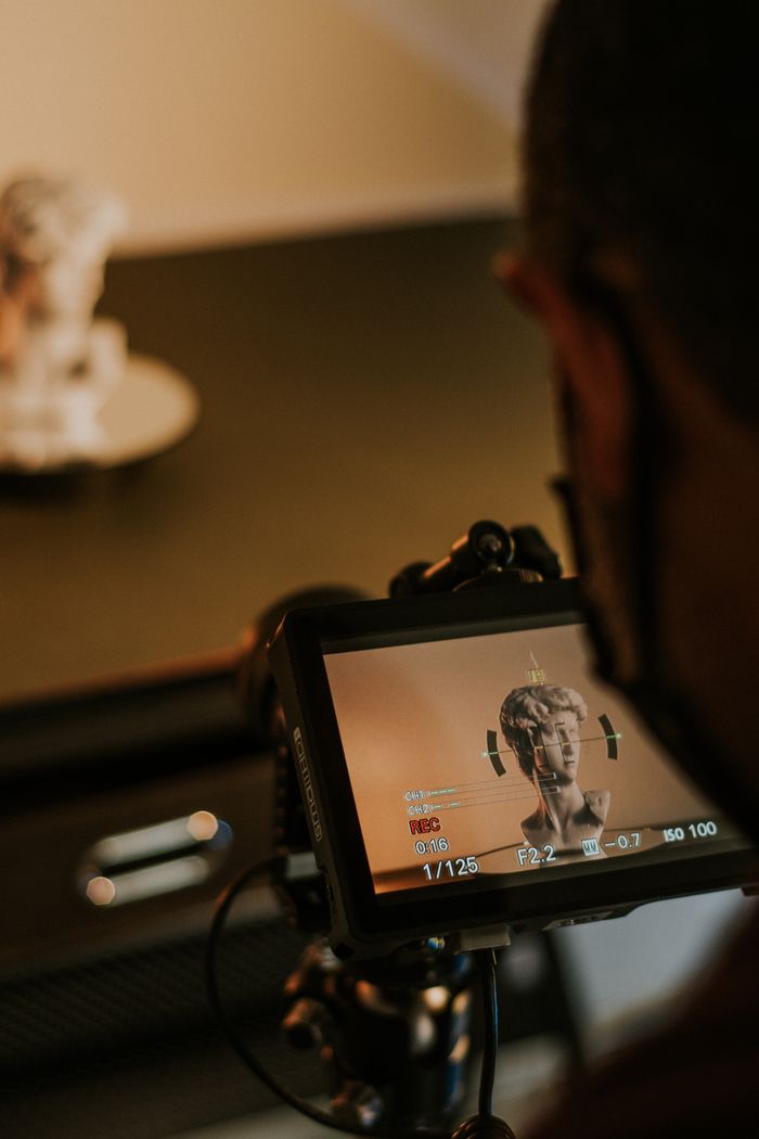 journey A video camera focuses on a marble head bust sculpture inside a studio setting.